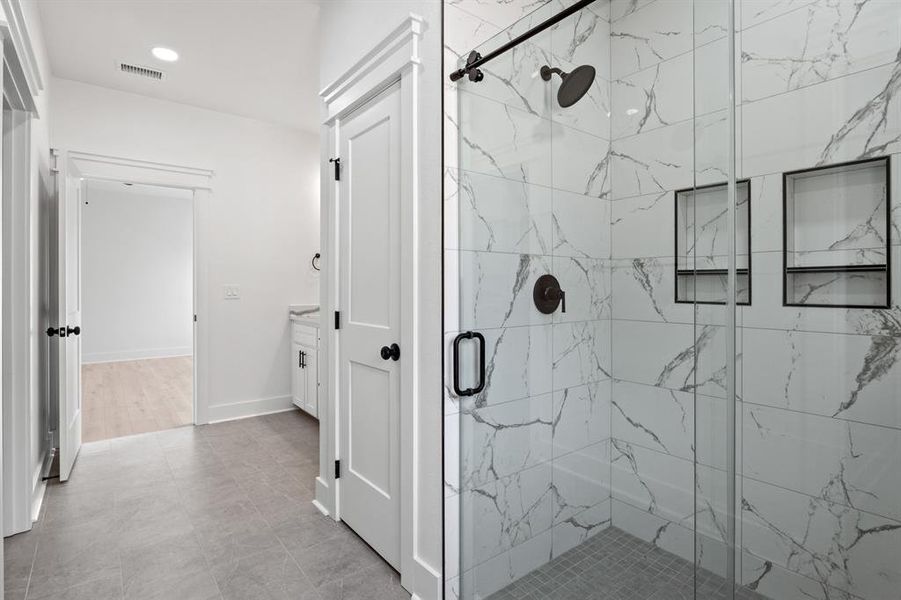 Full bathroom featuring a marble finish shower and recessed lighting