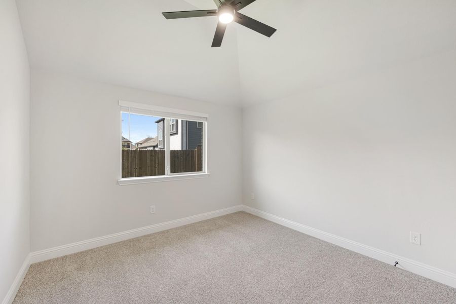 Empty bedroom with vaulted ceiling, ceiling fan, carpet flooring, and single window