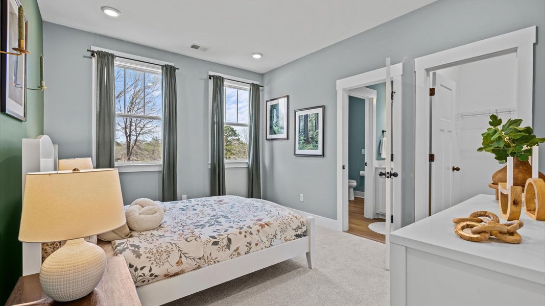 Superior comfort in this light-filled bedroom with plush carpeting and thoughtfully placed large windows