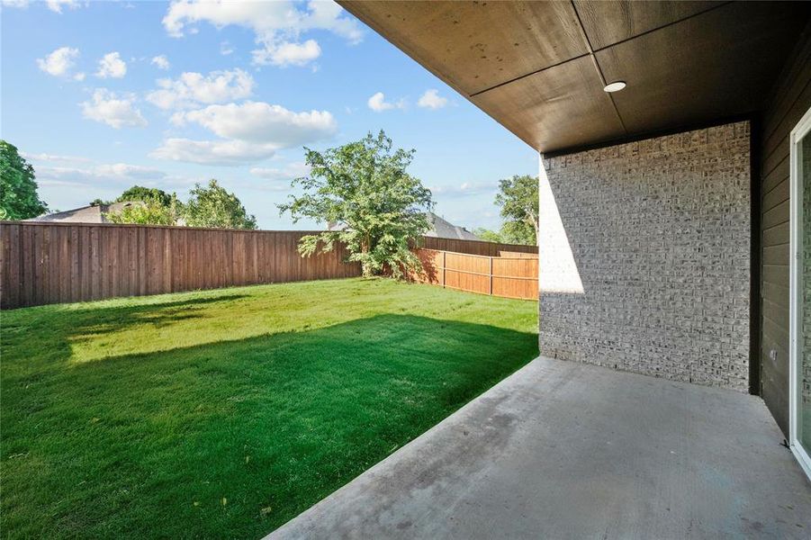 Fenced backyard with a patio area Fenced backyard with a patio area