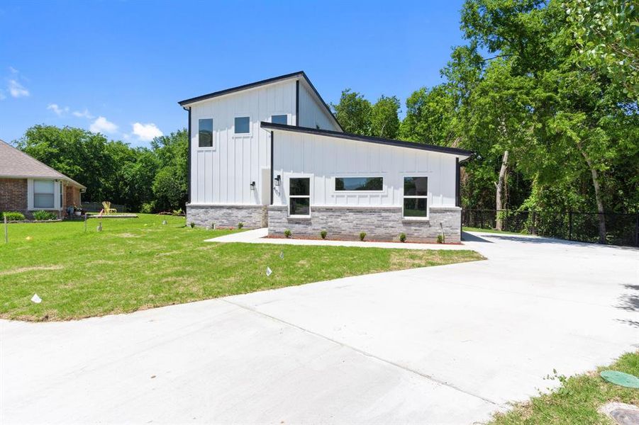 View of front of property with board and batten siding, brick siding, and driveway View of front of property with board and batten siding, brick siding, and driveway