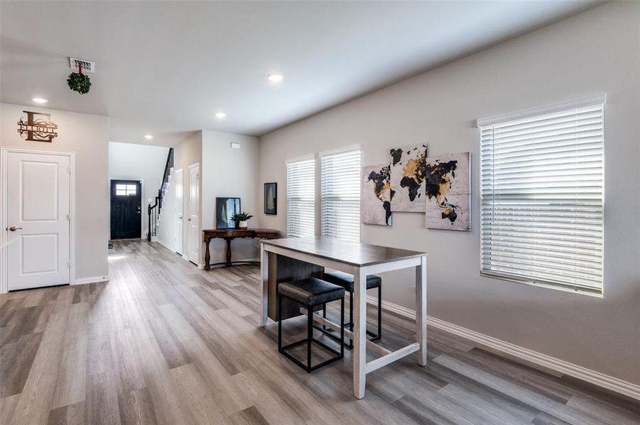 Dining area with light wood finished floors and recessed lighting
