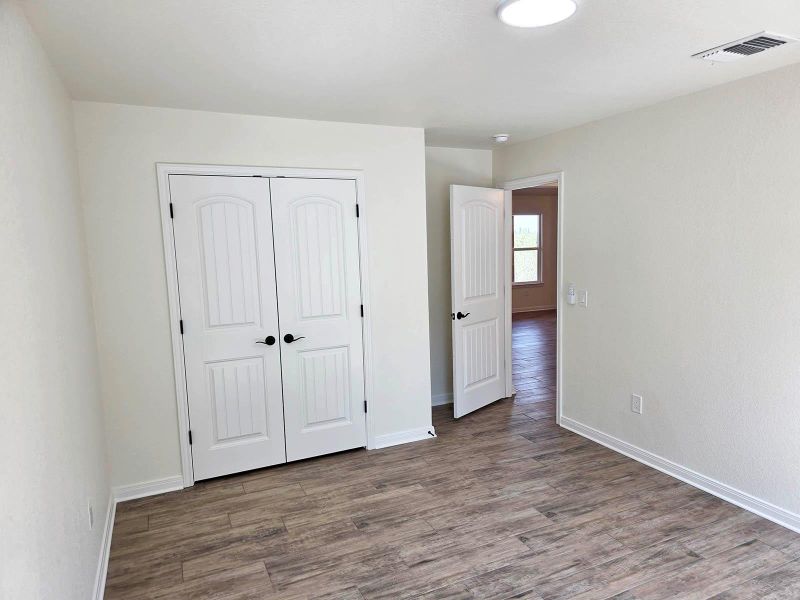 Unfurnished bedroom with wood finished floors and a closet