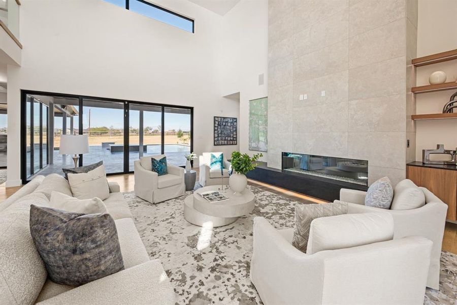 Great room with soaring ceilings, sleek fireplace, and wall-to-wall windows. Great room with soaring ceilings, sleek fireplace, and wall-to-wall windows.