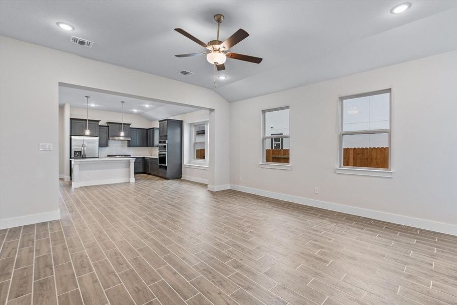 An open concept living area boasts a modern kitchen with sleek appliances and durable tile flooring. An open concept living area boasts a modern kitchen with sleek appliances and durable tile flooring.