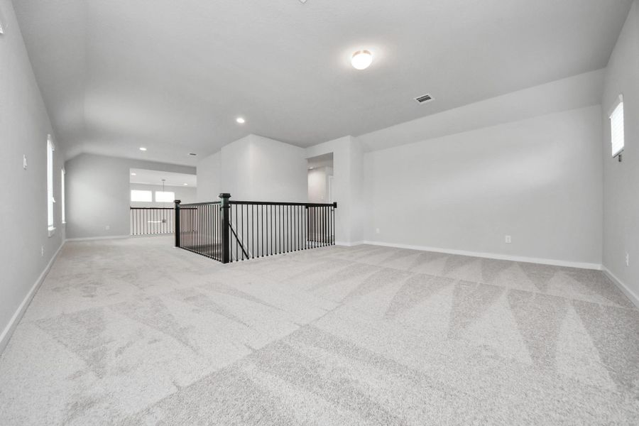 Come upstairs and enjoy a day of leisure in this fabulous game room! This is the perfect hangout spot or adult game room! Features plush carpet, high ceilings, custom paint and windows for plenty of natural light. Sample photo of completed home with similar floor plan. Actual colors and selections may vary.