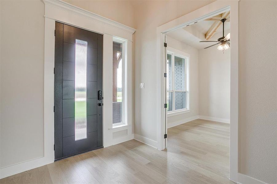 Entryway with ceiling fan and light wood-type flooring