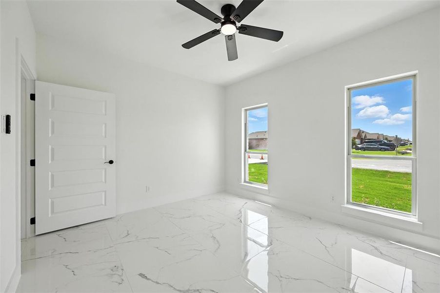 Spare room with marble finish flooring and ceiling fan