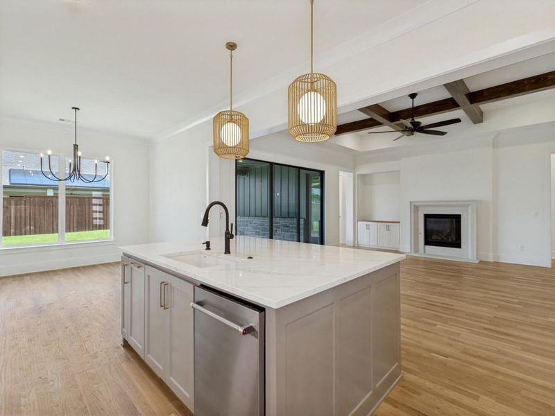 Kitchen island with a white stone countertop, integrated sink, and stainless steel dishwasher Kitchen island with a white stone countertop, integrated sink, and stainless steel dishwasher