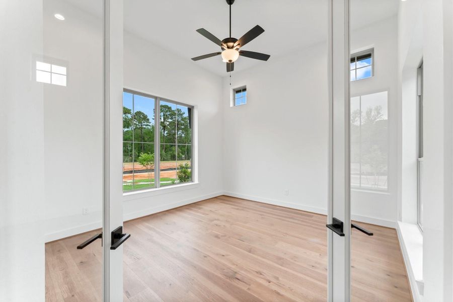 Study/Home Office with Engineered Wood Flooring, Fan, and Lots of Natural Light.