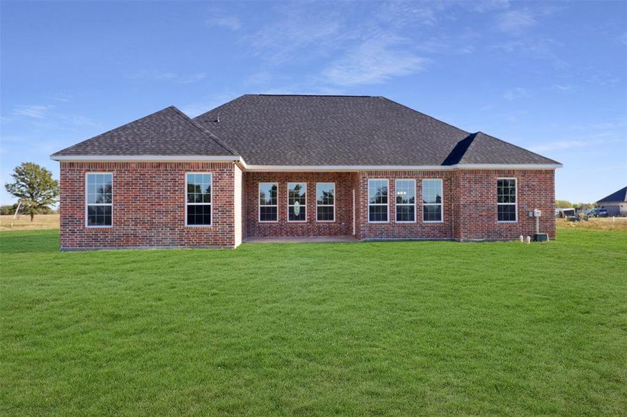 Rear view of property with a yard