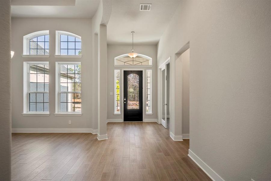 Basking in the natural light streaming through elegant arched windows, casting a warm glow on the tile flooring. This inviting foyer is your runway to the chic lifestyle offered by the Cornell.