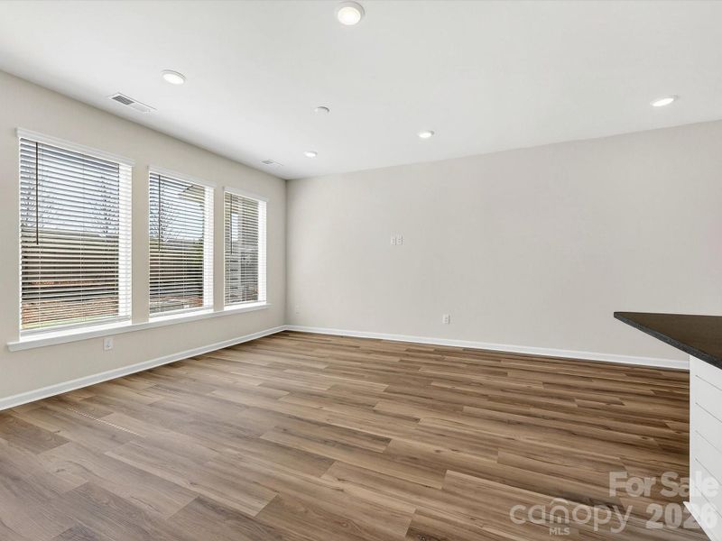 open, bright living room with 3 large picture windows bathes the area with natural light