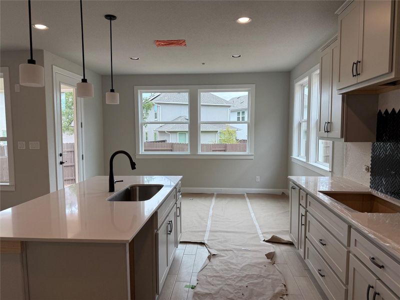 Kitchen with healthy amount of natural light, light countertops, light wood-style floors, and recessed lighting Kitchen with healthy amount of natural light, light countertops, light wood-style floors, and recessed lighting