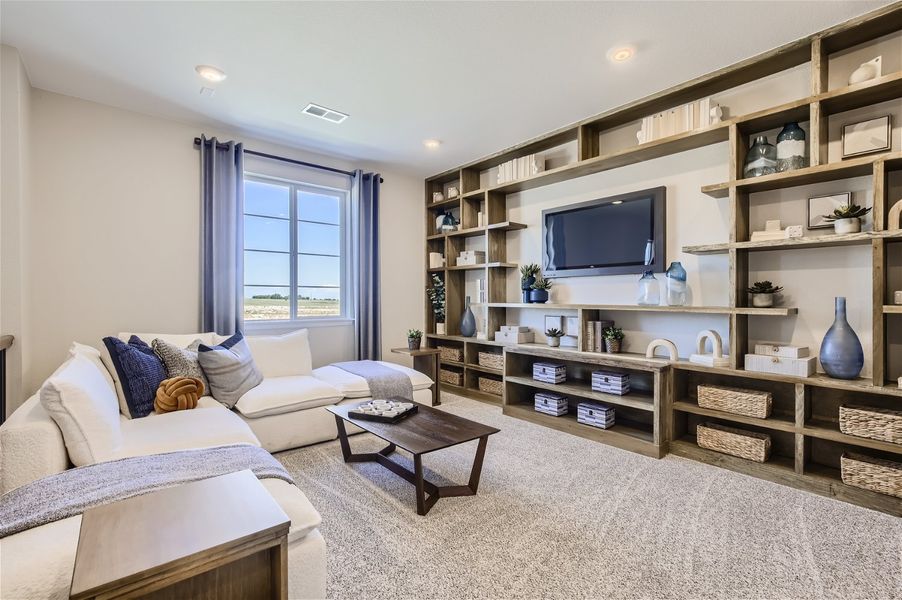 A living room with a tv and couches. A living room with a tv and couches.