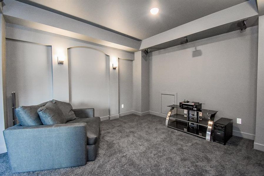 An enclosed media room equipped with wall sconces, surround sound capabilities, and overhead projector prewiring creates an immersive viewing experience. Enjoy a cozy atmosphere, enhancing movie nights or gaming sessions with high-quality audio and visual performance.