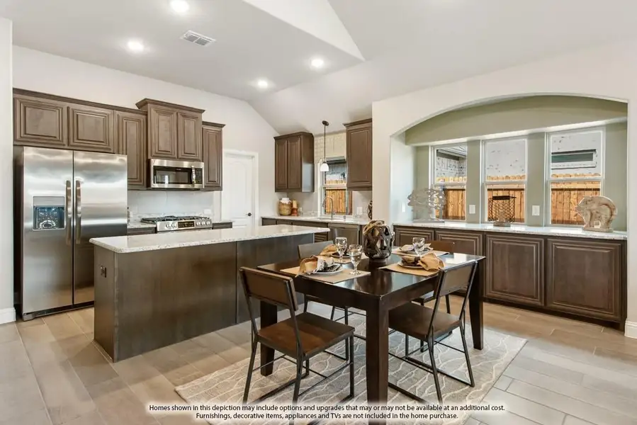 Kitchen and dining area with dark wood cabinets, granite island, stainless appliances, and four-seat dining table on light wood floors