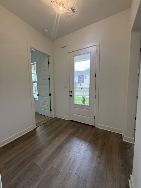 Entryway featuring wood-finish flooring and a white paneled door with a clear glass insert