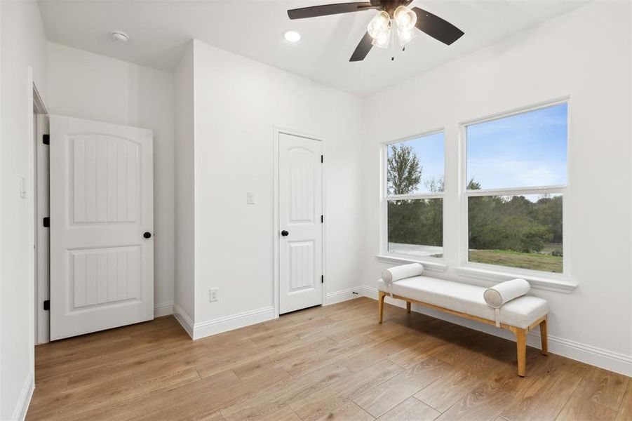 Sitting room featuring ceiling fan and light wood-type flooring