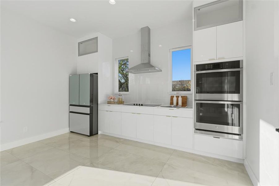 Kitchen featuring white cabinets, modern cabinets, double oven, light countertops, and recessed lighting Kitchen featuring white cabinets, modern cabinets, double oven, light countertops, and recessed lighting