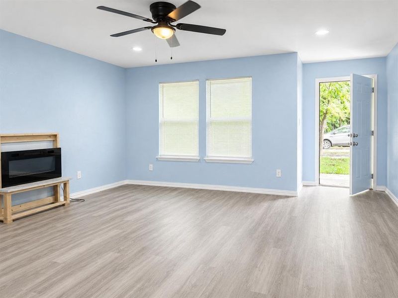 Bright living area featuring wood-finish flooring, recessed lighting, and a ceiling fan