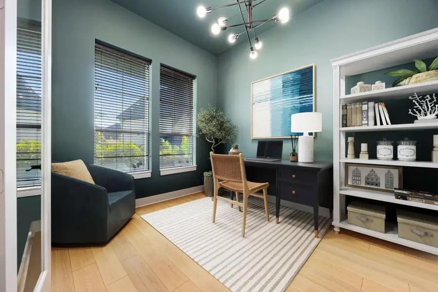 This room offers a bright and versatile space with multiple windows filling the area with natural light. The warm wood-look flooring and sleek modern lighting create a stylish backdrop, perfect for use as a home office, study, or creative retreat.