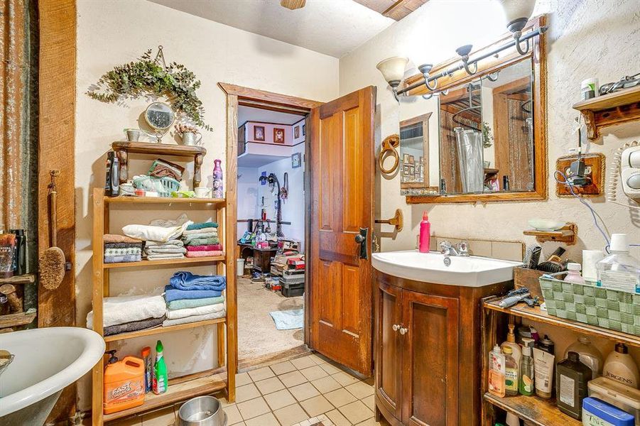 Full bathroom featuring light tile patterned floors, vanity, and a freestanding bath Full bathroom featuring light tile patterned floors, vanity, and a freestanding bath