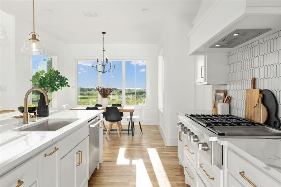 Gas cooktop, custom vent hood, and pitch-perfect backsplash.