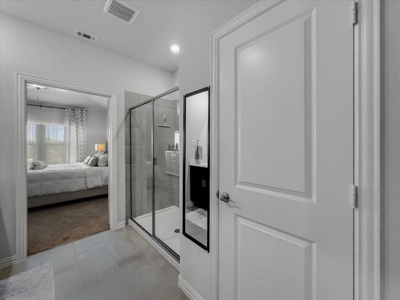 Bathroom with a shower with door and tile patterned flooring