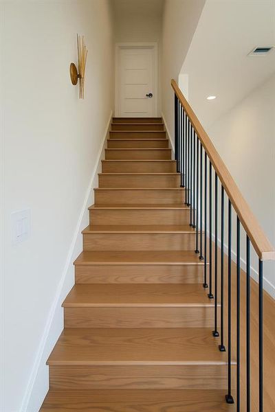 Stairs featuring wood finished floors and baseboards Stairs featuring wood finished floors and baseboards