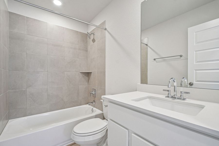 A bathroom with a tub sink and toilet.