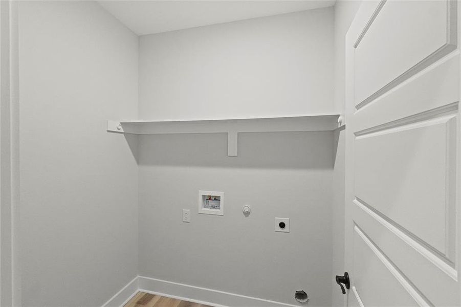 Clothes washing area with electric dryer hookup, hookup for a gas dryer, hookup for a washing machine, and hardwood / wood-style flooring