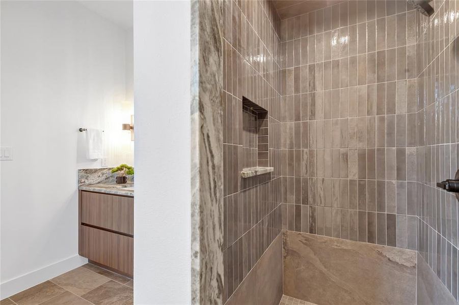 Bathroom featuring tiled shower and vanity Bathroom featuring tiled shower and vanity
