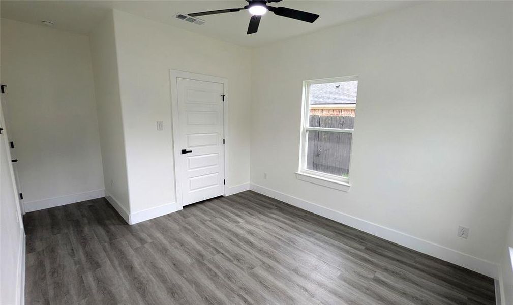 Unfurnished bedroom featuring baseboards, visible vents, and dark wood-style floors
