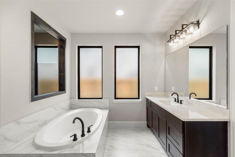 Beautiful Fixtures and Quartz Countertops and Porcelain Tile in Primary Bathroom