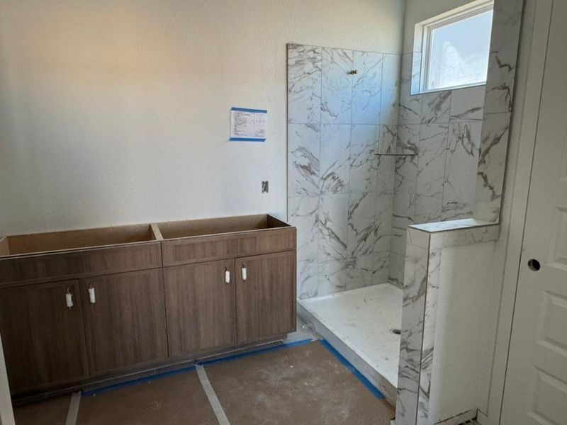 Bathroom with a marble finish shower and vanity Bathroom with a marble finish shower and vanity