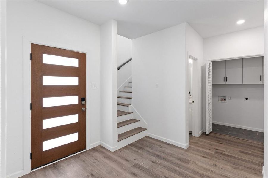 Entryway with stairs, wood finished floors, recessed lighting, and baseboards Entryway with stairs, wood finished floors, recessed lighting, and baseboards