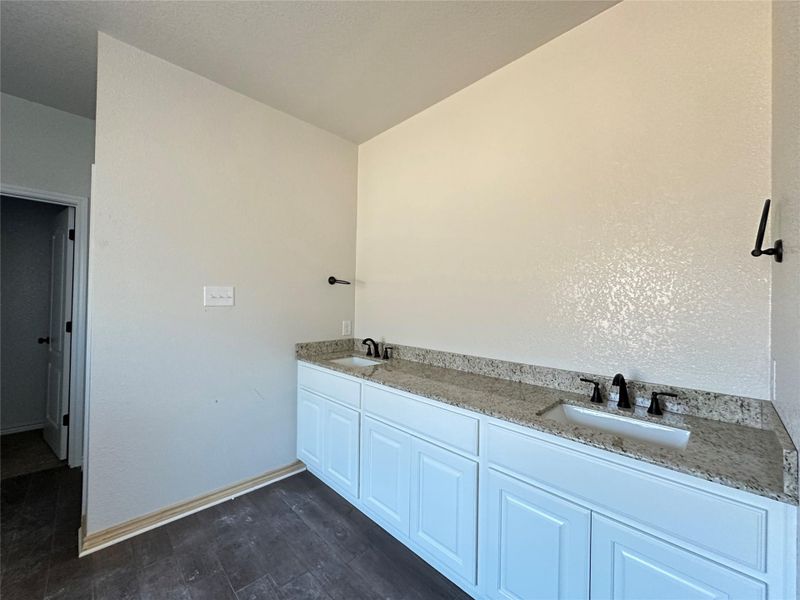 Bathroom featuring double vanity and dark wood-type flooring