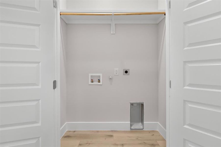 Laundry area with hookup for a gas dryer, light hardwood / wood-style flooring, washer hookup, and hookup for an electric dryer