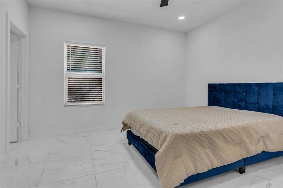 Bedroom featuring marble look tile flooring, recessed lighting, and a ceiling fan Bedroom featuring marble look tile flooring, recessed lighting, and a ceiling fan