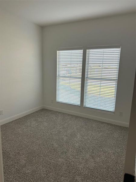 Carpeted empty room featuring baseboards