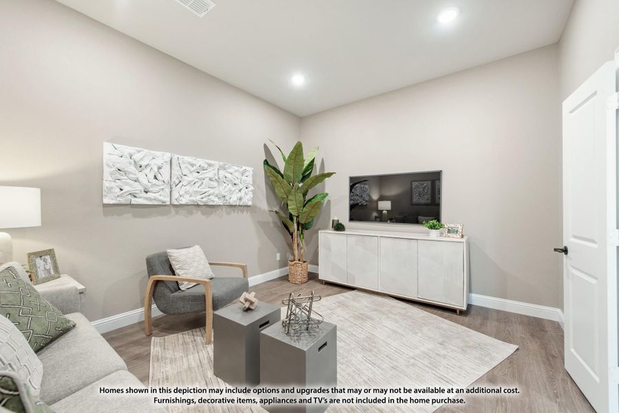Living room with hardwood floors, gray seating, white media console, and wall art on beige walls Living room with hardwood floors, gray seating, white media console, and wall art on beige walls
