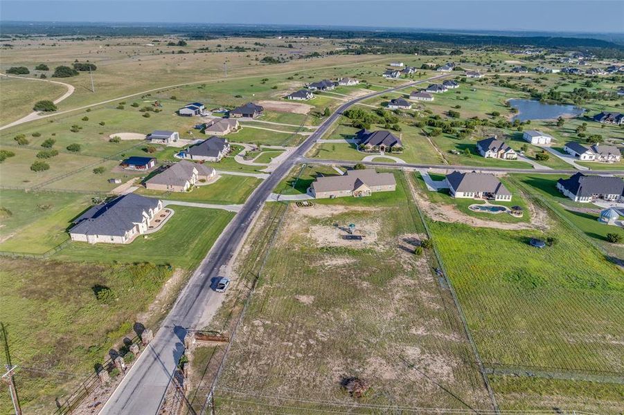 Aerial view of property's location featuring a large body of water and nearby suburban area