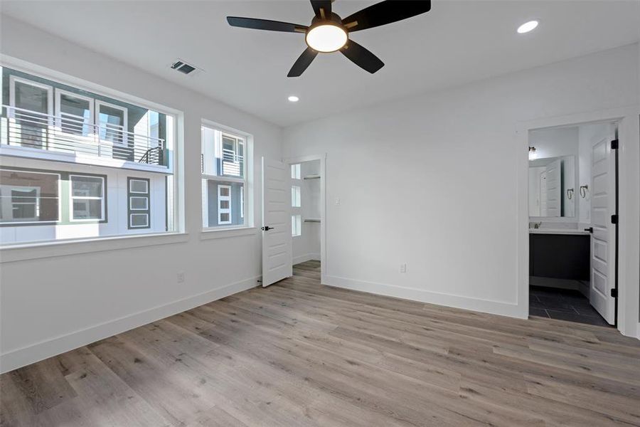 The door to the right leads to the full ensuite bath. A wall of windows make this bedroom very bright.