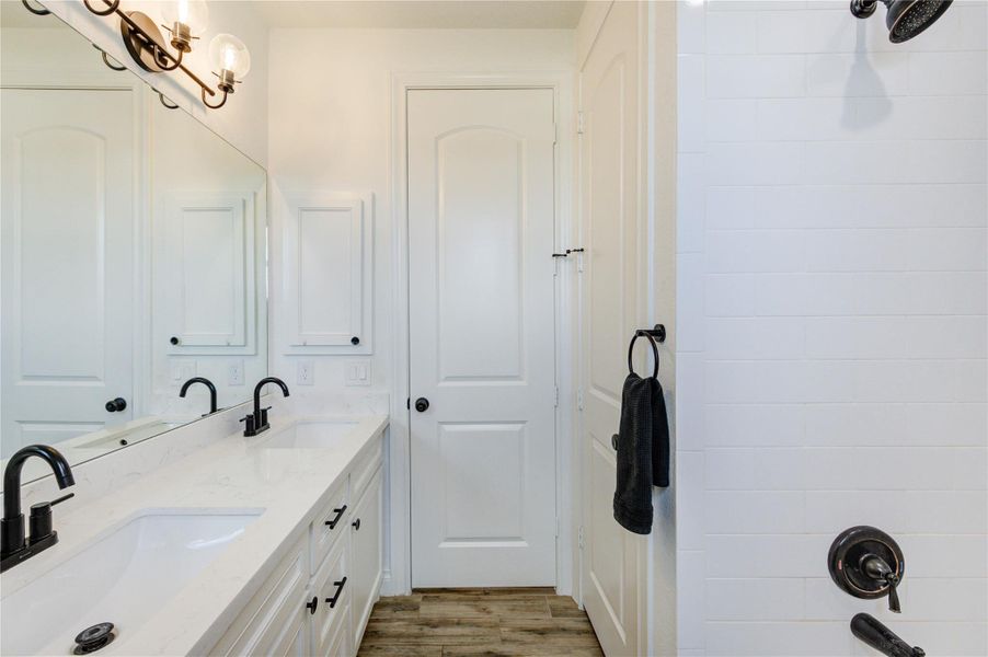 Full bathroom with double vanity, quartz counters, and modern black finishes.