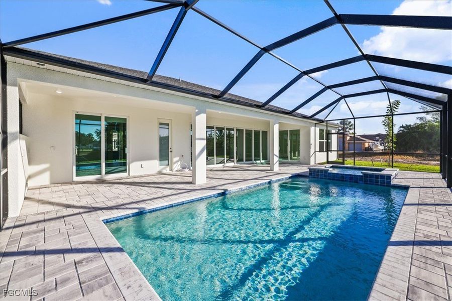 View of pool with a sunroom, a patio, a pool with connected hot tub, and a lanai