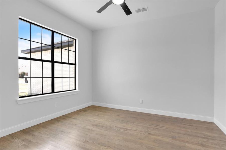 Unfurnished room with ceiling fan and light wood-type flooring