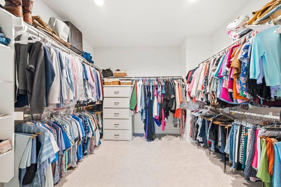 A spacious walk-in closet boasts extensive built-in organizing systems and wall-to-wall carpeting. A spacious walk-in closet boasts extensive built-in organizing systems and wall-to-wall carpeting.