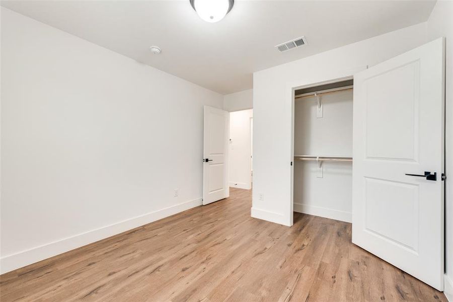 Unfurnished bedroom with a closet and light hardwood / wood-style flooring