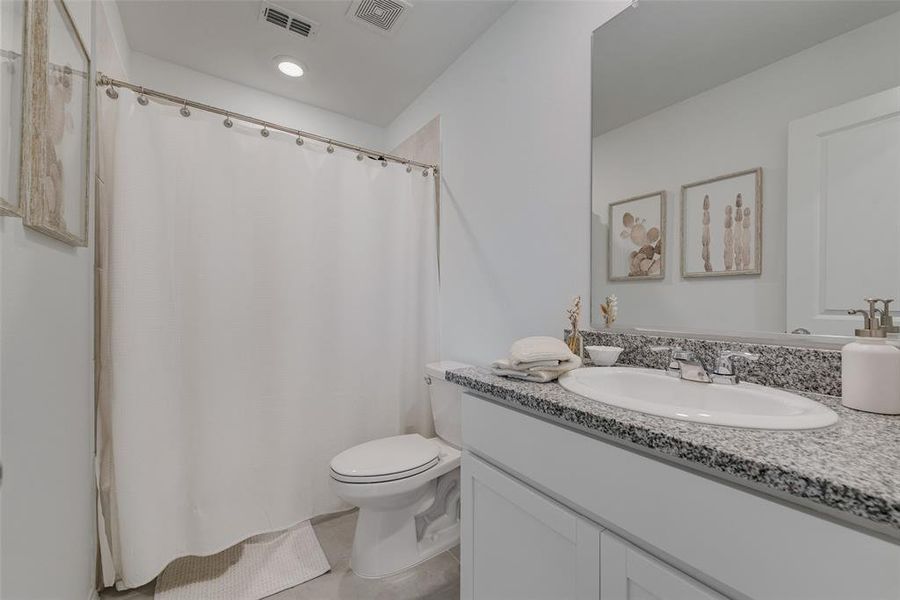 Bathroom with vanity and curtained shower Bathroom with vanity and curtained shower